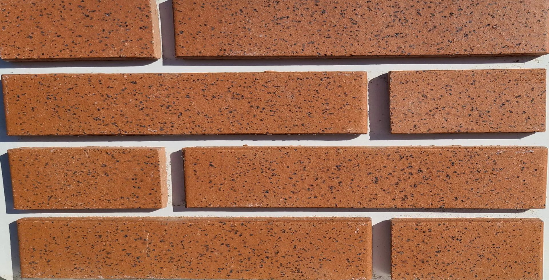 The close up view of smooth red brick on white wall