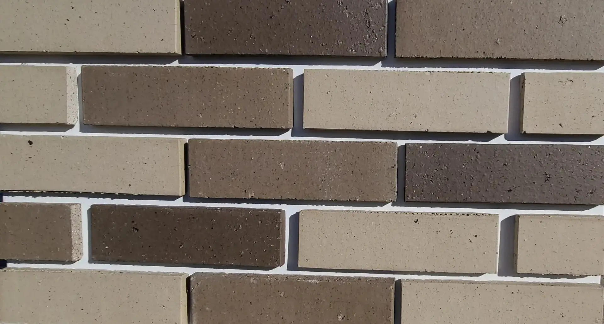 The close up view of off white and grey shade brick wall